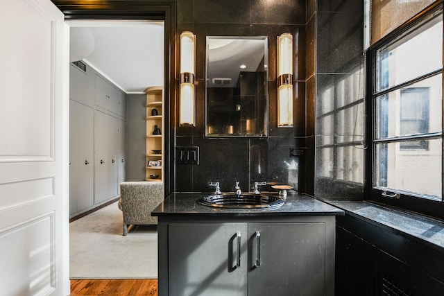 bathroom featuring hardwood / wood-style flooring, vanity, and backsplash