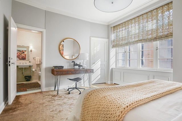 carpeted bedroom with crown molding and ensuite bath