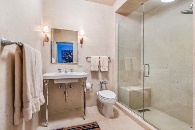 bathroom with sink, tile walls, toilet, a shower with door, and tile patterned floors