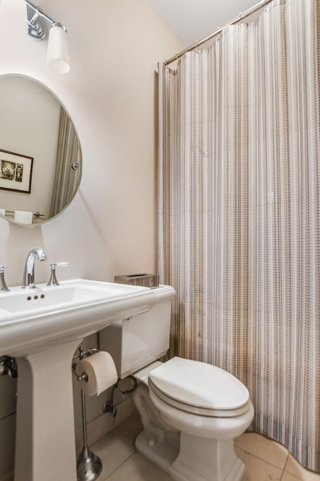 bathroom featuring a shower with curtain, tile patterned floors, and toilet