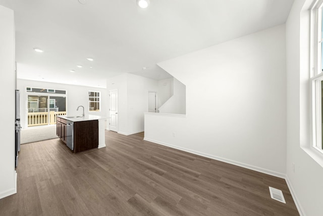 kitchen featuring dark hardwood / wood-style floors, sink, an island with sink, and dark brown cabinets