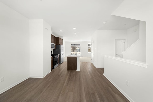 kitchen with dark wood-type flooring, sink, dark brown cabinets, appliances with stainless steel finishes, and a kitchen island