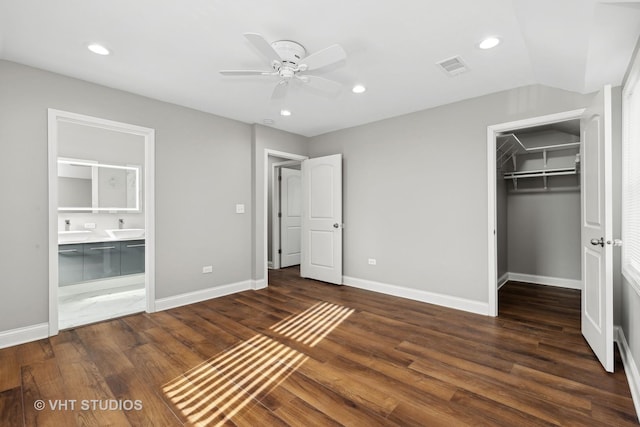 unfurnished bedroom with sink, a spacious closet, dark wood-type flooring, and a closet