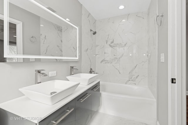 bathroom with tiled shower / bath and vanity