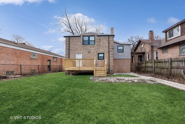 rear view of property featuring a yard and a deck