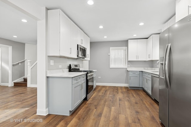 kitchen with white cabinetry, dark hardwood / wood-style flooring, gray cabinets, and stainless steel appliances