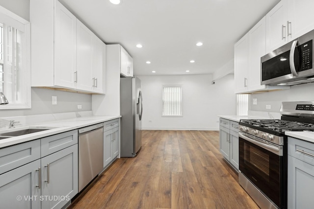 kitchen featuring stainless steel appliances, white cabinetry, dark hardwood / wood-style floors, and gray cabinetry