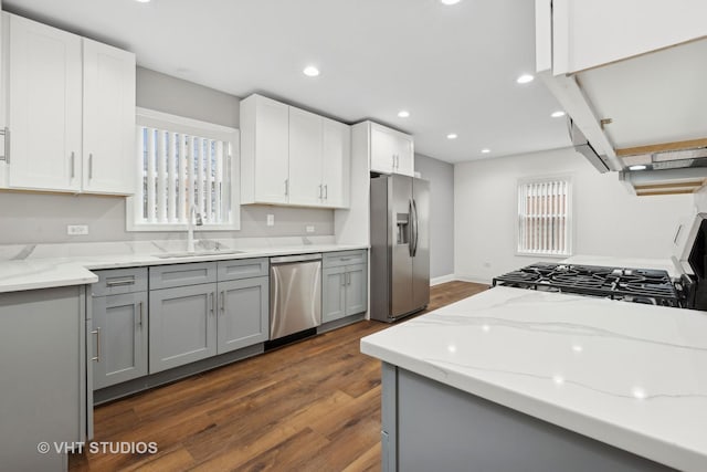 kitchen featuring light stone counters, sink, gray cabinets, and stainless steel appliances