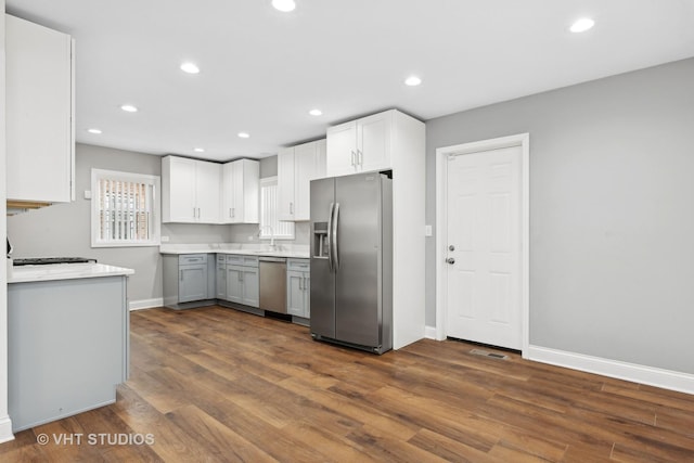 kitchen with stainless steel appliances, dark hardwood / wood-style floors, sink, and white cabinets