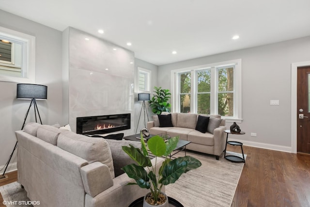 living room featuring a tiled fireplace and hardwood / wood-style flooring