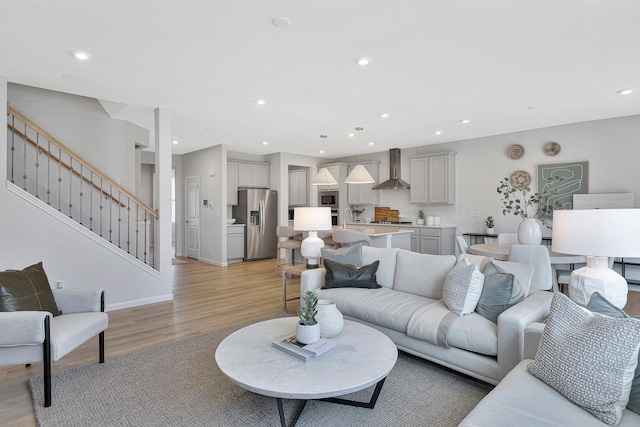 living room featuring stairway, recessed lighting, and light wood-type flooring