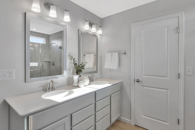 full bath with double vanity, a stall shower, and a sink