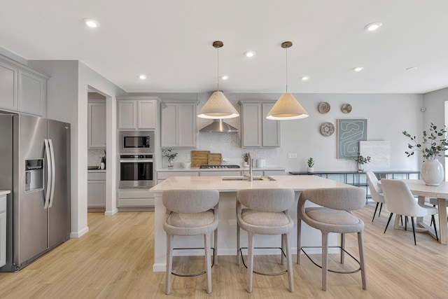 kitchen with light countertops, appliances with stainless steel finishes, gray cabinetry, and a sink