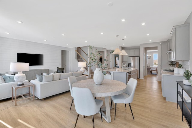 dining area with recessed lighting, light wood-style floors, and stairway