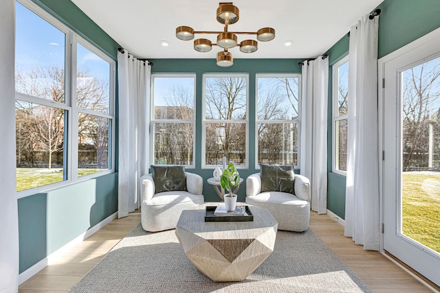 sunroom / solarium featuring plenty of natural light and a chandelier