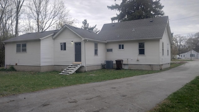 back of house featuring cooling unit and a yard