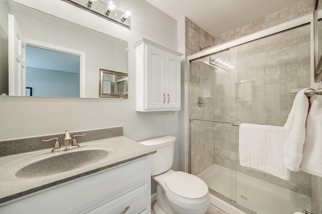 bathroom featuring walk in shower, vanity, and toilet