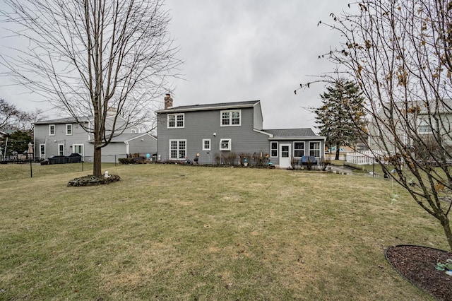 rear view of house featuring a yard