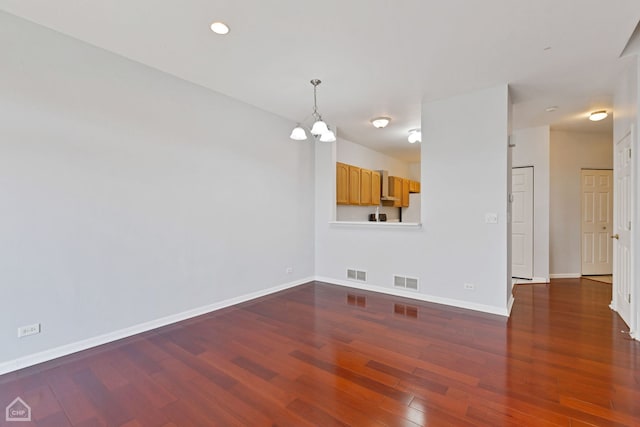 unfurnished room with dark hardwood / wood-style floors and a notable chandelier