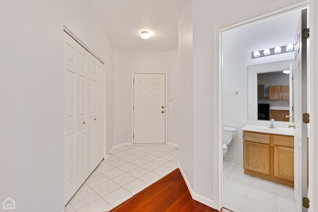 hallway featuring sink and light tile patterned floors