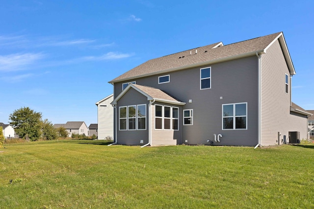 back of property with a yard and central air condition unit