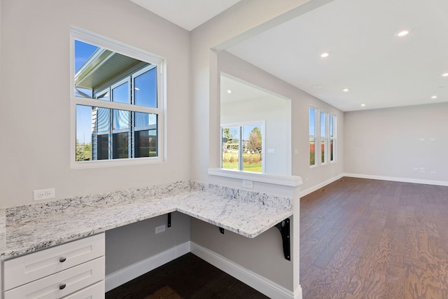 interior space with built in desk and dark hardwood / wood-style flooring