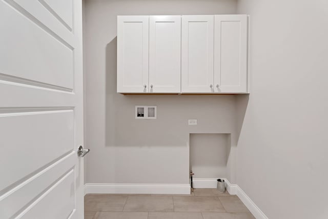 clothes washing area with gas dryer hookup, light tile patterned floors, hookup for a washing machine, and cabinets