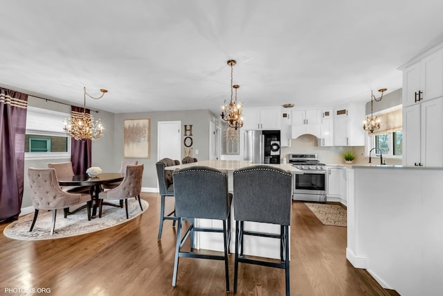 kitchen featuring white cabinetry, stainless steel appliances, a chandelier, and a kitchen island