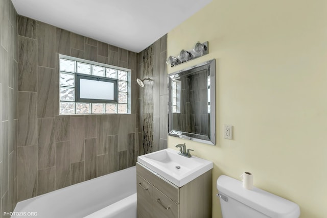 full bathroom featuring tiled shower / bath combo, vanity, and toilet