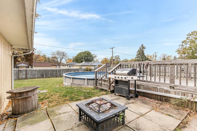 view of patio with a fenced in pool, grilling area, and an outdoor fire pit