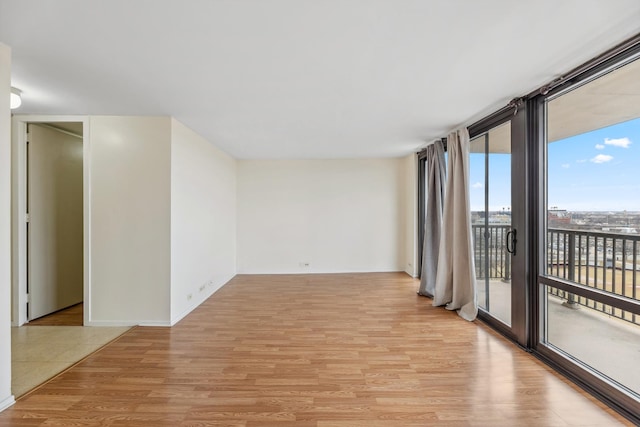 empty room with expansive windows and light wood-type flooring