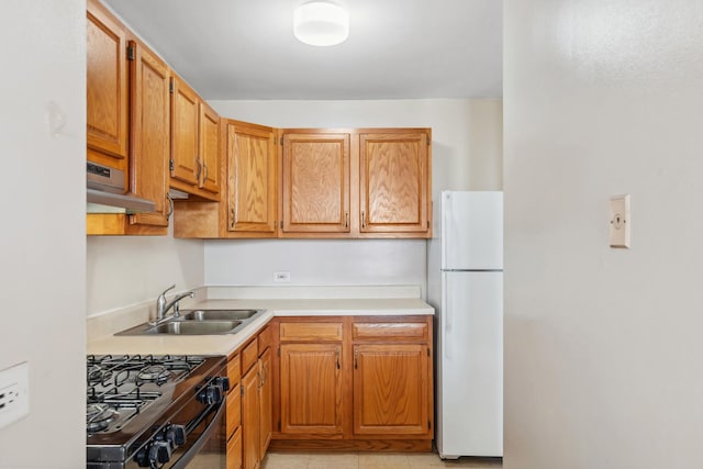 kitchen with extractor fan, sink, white fridge, fridge, and black range with gas cooktop