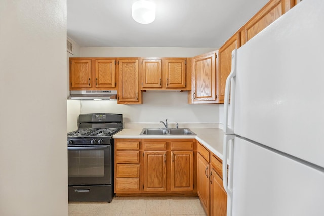 kitchen with sink, black gas stove, and white refrigerator