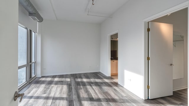 unfurnished room with wood finished floors and baseboards