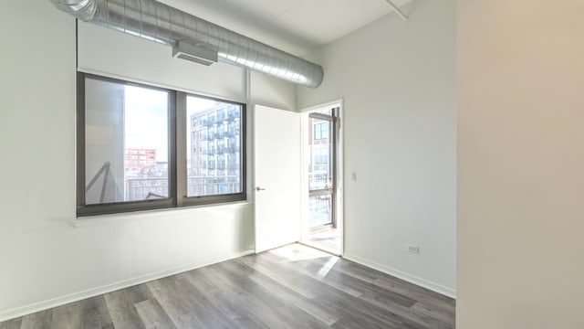 spare room featuring wood finished floors and baseboards