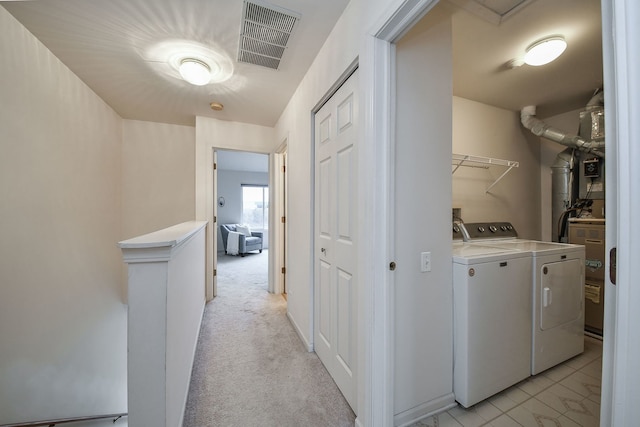 clothes washing area with light colored carpet and washing machine and dryer