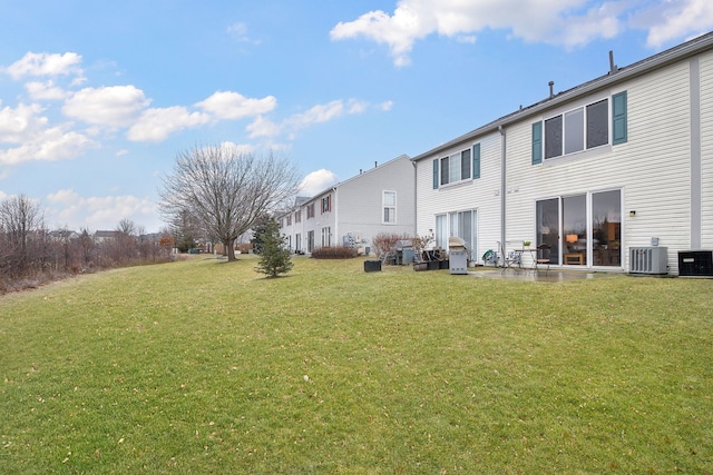 back of house with central AC and a yard