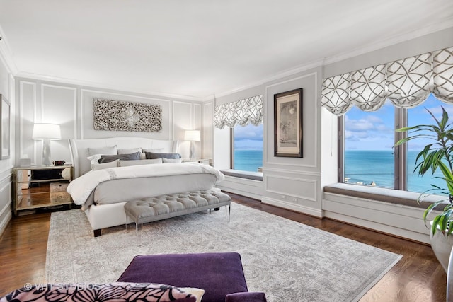 bedroom featuring a water view, ornamental molding, and dark wood-type flooring