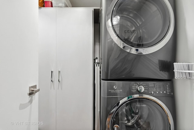 clothes washing area featuring stacked washing maching and dryer