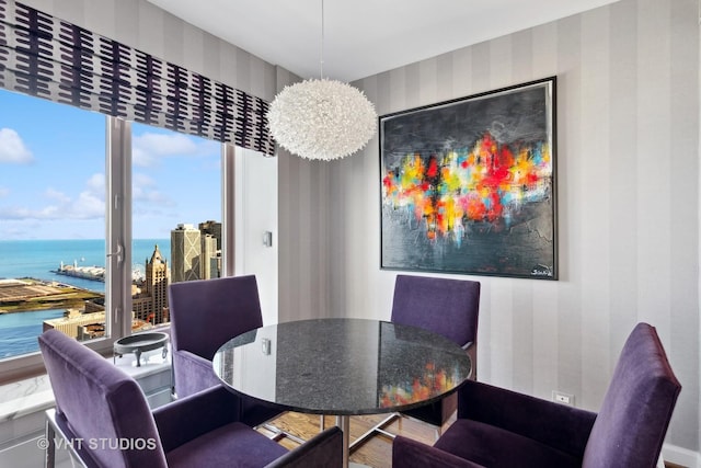 dining space featuring a water view and a notable chandelier