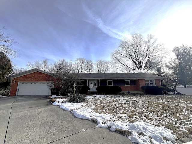 ranch-style house with a garage, driveway, and brick siding