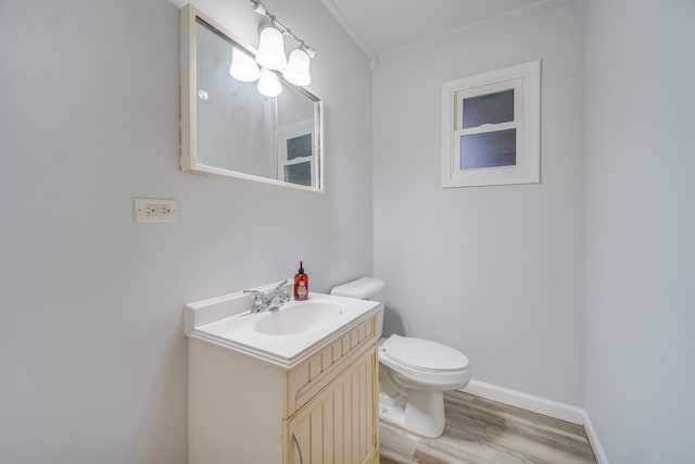 bathroom with vanity, hardwood / wood-style floors, ornamental molding, and toilet