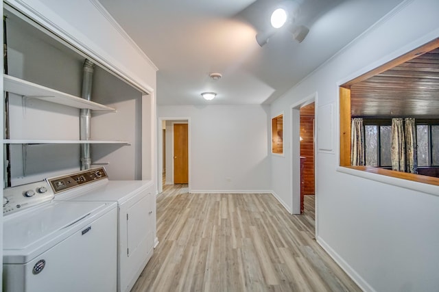 washroom with crown molding, washer and clothes dryer, and light hardwood / wood-style floors