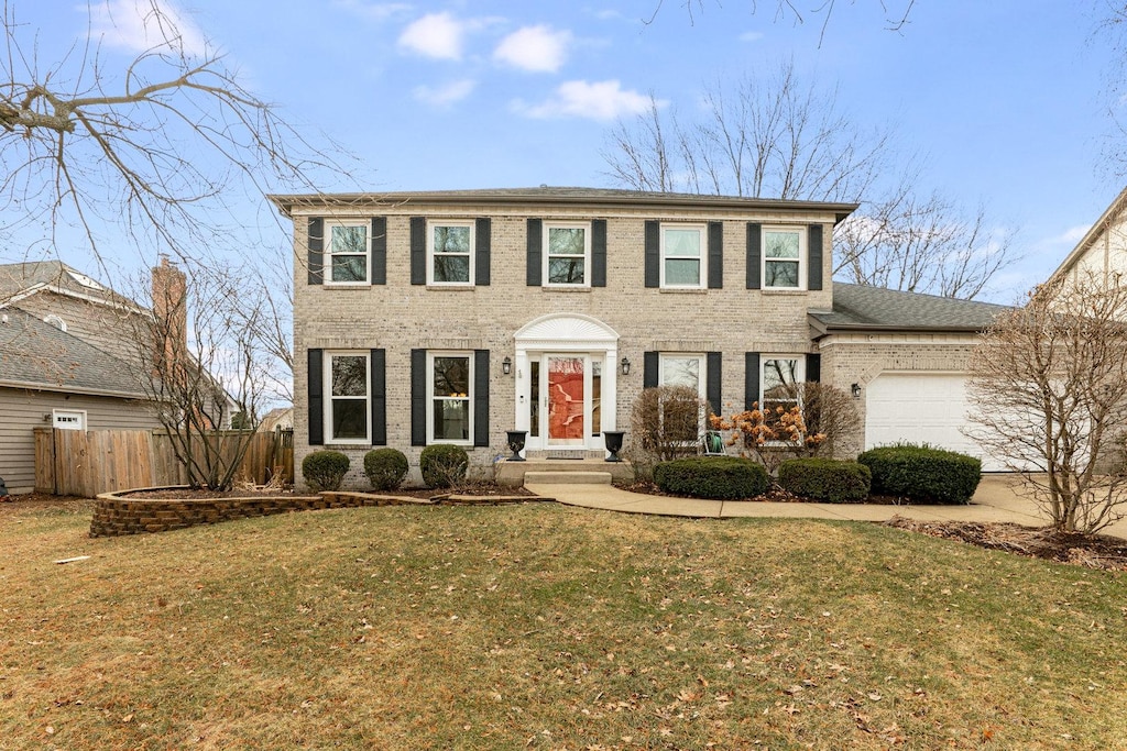 colonial home with a garage and a front yard