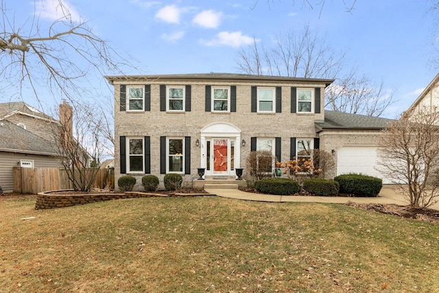 colonial inspired home featuring a garage and a front lawn