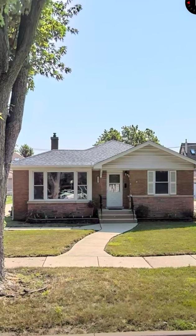 ranch-style home featuring a front lawn