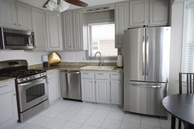 kitchen featuring ceiling fan, stainless steel appliances, sink, and light tile patterned floors