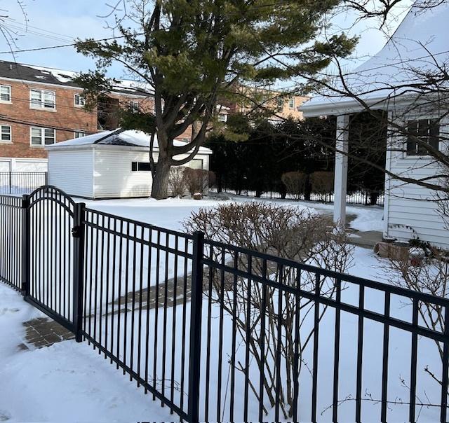 snow covered gate featuring an outbuilding