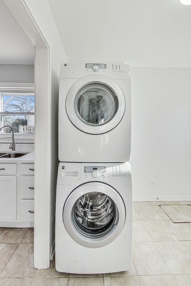 washroom with stacked washer and dryer, sink, and light tile patterned floors