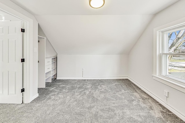 additional living space with vaulted ceiling and light carpet